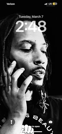 a picture of a man with dreadlocks on his phone